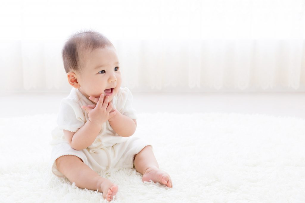 asian baby relaxing on the carpet